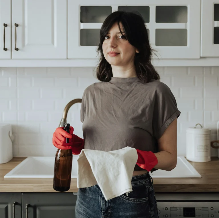 woman with cleaning cloth and vinegar spray bottle